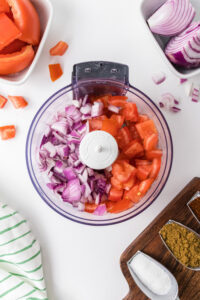 food processor with tomatoes and onions